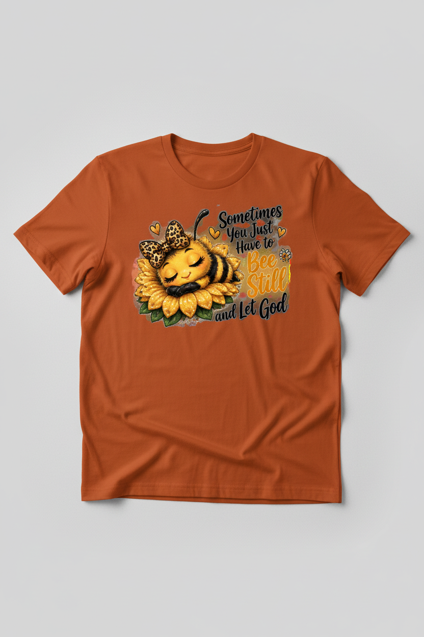 Bee Still and Let God bee and sunflower design on a rust orange T-shirt